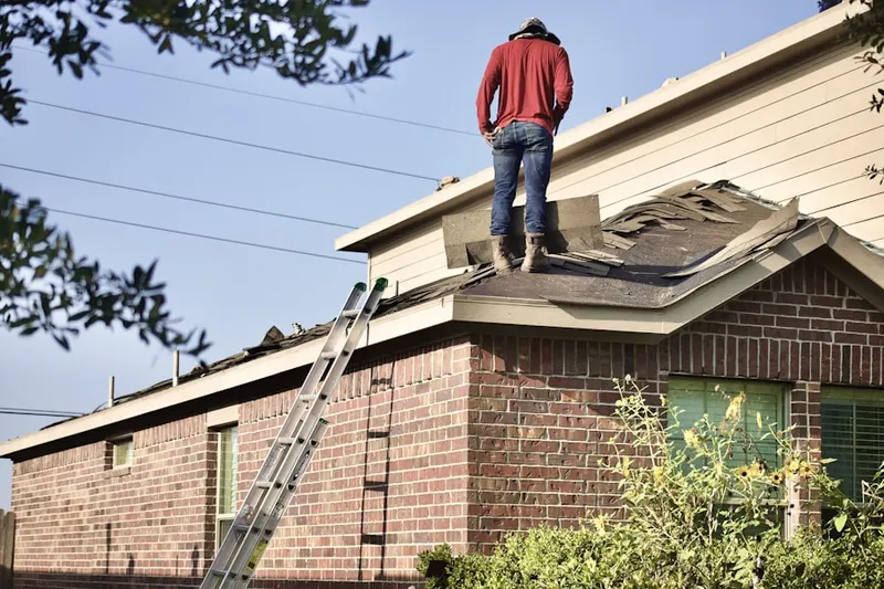 Professional roofer working on a residential roof in Dryden